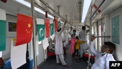 FILE - Passengers ride in a newly built Orange Line Metro Train, a metro project planned under the China-Pakistan Economic Corridor, a day after an official opening in the eastern city of Lahore, Oct. 26, 2020.