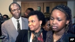 Léon Mugesera (à gauche) sort d'un tribunal à Québec, le 12 avril 2001, en compagnie de sa femme (au c.) et de sa fille (à dr.).