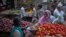 FILE - An Indian woman buys vegetables at a road side stall in New Delhi, Aug. 20, 2014. 