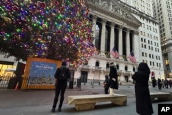 FILE - People photograph the New York Stock Exchange in New York's Financial District, Dec. 23, 2024.