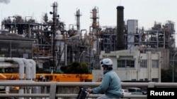 Seorang pekerja bersepeda di dekat sebuah pabrik di kawasan industri Keihin, Kawasaki, Jepang, 8 Maret 2017. (Foto: dok). 