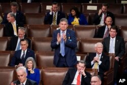 Sen. Joe Manchin, D-W.Va., stands and applauds as he sits among Republican Senators as President Joe Biden delivers his first State of the Union address to a joint session of Congress, at the Capitol in Washington, March 1, 2022. (AP Photo/J. Scott Applewhite, Pool)