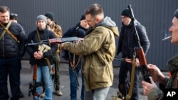 Civilian Members of a territorial defense unit fit their weapons to repel the Russian attacking forces in Kyiv, Ukraine, Feb. 26, 2022.