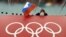 FILE - A Russian flag is held above the Olympic Rings at Adler Arena Skating Center during the Winter Olympics in Sochi, Russia, Feb. 18, 2014.