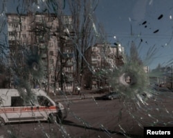 An ambulance is seen through the damaged window of a vehicle hit by bullets, as Russia's invasion of Ukraine continues, in Kyiv, Ukraine, Feb. 28, 2022. (Jedrzej Nowicki/Agencja Wyborcza.pl via Reuters)