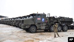 Arhiva - Oklopna vozila na platformama kamiona, kao deo dodatnih snaga Velike Britanije i vojne opreme pristigle u bazu NATO borbene grupe u Estonii, u Tapi, 25. februara 2022.