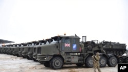 Tanks uploaded on military truck platforms as a part of additional British troops and military equipment arrive at Estonia's NATO Battle Group base in Tapa, Estonia, Feb. 25, 2022.