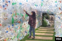 Instalasi gapura dari botol plastik, perilaku konsumtif menghasilkan sampah plastik yang sulit diurai di alam. (VOA/Petrus Riski)