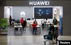 Wateja na wafanyakazi wakiwa katika duka la Huawei katika eneo la biashara la Sandton City, Sandton, Afrika Kusini, Feb. 16, 2022.