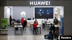 FILE - Customers and employees are seen at a Huawei store at Sandton City mall in Sandton, South Africa, Feb. 16, 2022.