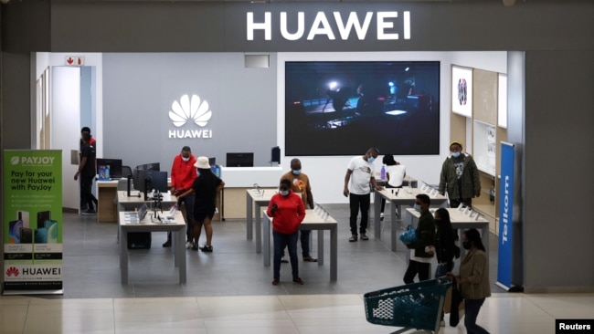 FILE - Customers and employees are seen at a Huawei store at Sandton City mall in Sandton, South Africa, Feb. 16, 2022.