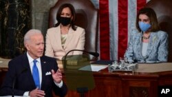 FILE - U.S. President Joe Biden addresses a joint session of Congress, April 28, 2021, in the House Chamber at the U.S. Capitol in Washington, as Vice President Kamala Harris, left, and House Speaker Nancy Pelosi look on.