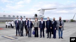 Taiwan's Foreign Minister Joseph Wu, fourth from right, stands with an American delegation including former Chairman of the Joint Chiefs Adm. Mike Mullen, third from right, as they arrive at Taipei Songshan Airport in Taipei, Taiwan, Tuesday, March 1, 2022.