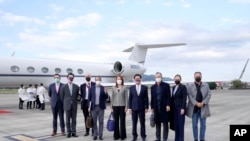 Taiwan's Foreign Minister Joseph Wu, fourth from right, stands with an American delegation including former Chairman of the Joint Chiefs Adm. Mike Mullen, third from right, as they arrive at Taipei Songshan Airport in Taipei, Taiwan, Tuesday, March 1, 2022.