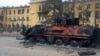 A destroyed Ukrainian armored personnel carrier vehicle is seen in front of a school which, according to local residents, was on fire after shelling, as Russia's invasion of Ukraine continues, in Kharkiv, Ukraine, Feb. 28, 2022. 