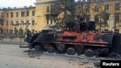 A destroyed Ukrainian armored personnel carrier vehicle is seen in front of a school which, according to local residents, was on fire after shelling, as Russia's invasion of Ukraine continues, in Kharkiv, Ukraine, Feb. 28, 2022. 