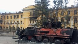 A destroyed Ukrainian armored personnel carrier vehicle is seen in front of a school which, according to local residents, was on fire after shelling, as Russia's invasion of Ukraine continues, in Kharkiv, Ukraine, Feb. 28, 2022.