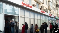 People stand in line to withdraw money from an ATM of Alfa Bank in Moscow, Russia. Feb. 27, 2022. 