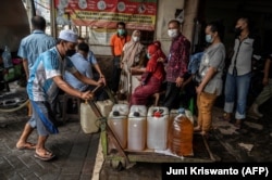 Warga antre membeli minyak goreng murah dari operasi pasar di Surabaya, Jawa Timur, 18 Februari 2022. Minyak jelantah dinilai sebagai salah satu alternatif pengembangan Bahan Bakar Nabati di Tanah Air. (Foto: Juni Kriswanto/AFP)