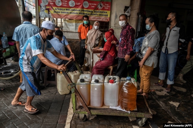Warga antre membeli minyak goreng murah dari operasi pasar di Surabaya, Jawa Timur, 18 Februari 2022. (Foto: Juni Kriswanto/AFP)