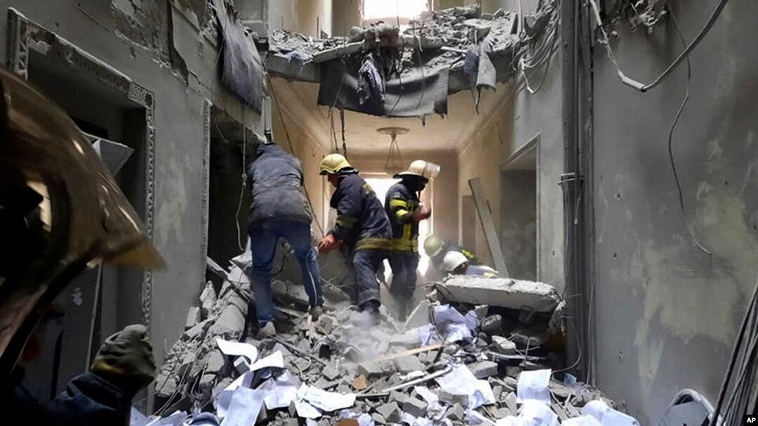 Petugas layanan darurat memeriksa kerusakan di dalam gedung Balai Kota di Kharkiv, Ukraina, Selasa, 1 Maret 2022. (Foto: via AP)
