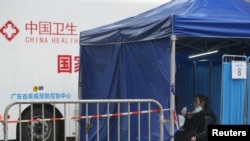 香港东涌居民在接受新冠病毒核酸检测，后面的车辆是中国广东省疾病预防控制中心的移动测试车。（2022年2月21日）