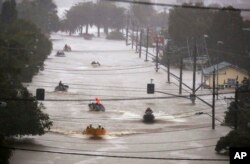 Orang-orang menggunakan perahu kecil melewati jalanan yang dilanda banjir di Lismore, Australia, Senin, 28 Februari 2022. (Jason O'Brien/AAP via AP)