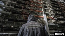 FILE - An employee works at the data center of a company providing services for cryptocurrency mining, in the city of Bratsk in Irkutsk region, Russia, March 2, 2021. 