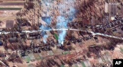 This satellite image provided by Maxar Technologies shows part of military convoy and burning homes northwest of Invankiv, Ukraine, Feb. 28, 2022. (Satellite image ©2022 Maxar Technologies via AP)