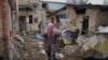 Una mujer luce abrumada en el patio trasero de una casa dañada por un ataque aéreo ruso, según lugareños, en Gorenka, en las afueras de Kiev, Ucrania, el 2 de marzo de 2022.