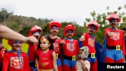 Niños disfrazados de SuperBigote hacen un gesto durante festividades en el parque Hugo Chávez, en el barrio Las Mayas, en Caracas, 27 de febrero de 2022. Foto: Reuters.