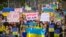 Ukrainians carried signs opposing to war and Russia President Vladimir Putin during a street march in Bangkok after Russia's invasion of Ukraine, Bangkok, Thailand, Feb.27, 2022 (Tommy Walker/VOA)
