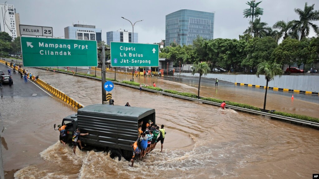 FILE - A military truck drives through the water on a flooded toll road following heavy rains in Jakarta, Indonesia, Saturday, Feb. 20, 2021. (AP Photo/Dita Alangkara, File)