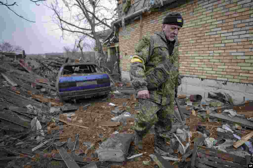 Andrey Goncharuk, a member of territorial defense, walks in the backyard of a house damaged by a Russian airstrike, according to locals, in Gorenka, outside the capital Kyiv, March 2, 2022. 