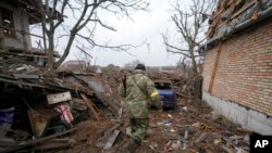 Andrey Goncharuk, 68, a member of territorial defense, walks in the backyard of a house damaged by a Russian airstrike, according to locals, in Gorenka, outside the capital Kyiv, Ukraine, March 2, 2022.