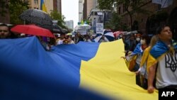 Hàng trăm người mang cờ Ukraine tuần hành dưới cơn mưa ở Sydney, Úc, để phản đối Nga xâm lược Ukraine, vào ngày 26/2/2022.