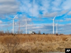 FILE - Land-based windmills in Atlantic City, N.J., help power a sewage treatment plant, taken Feb. 18, 2022. The new law includes $60 billion for clean energy manufacturing tax credit and $30 billion for a production tax credit for wind and solar. (AP Photo/Wayne Parry)