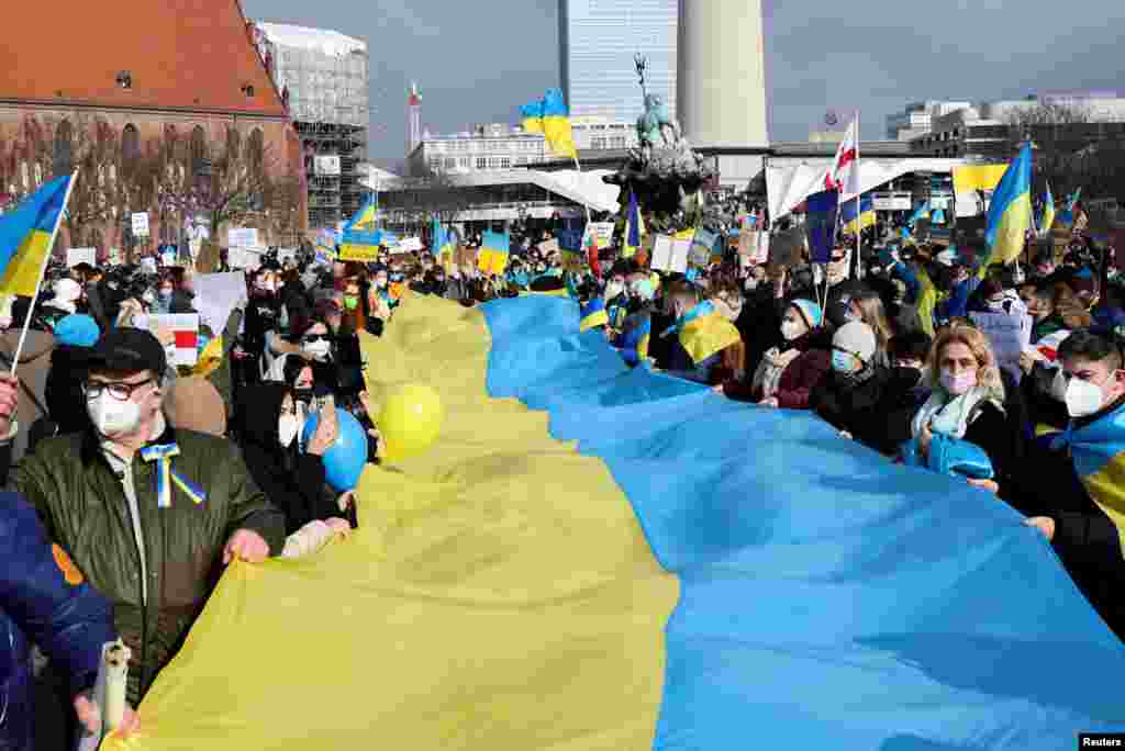 Los manifestantes sostienen una bandera ucraniana durante una protesta contra la guerra, después de que Rusia lanzara una operación militar masiva contra Ucrania, en Berlín, Alemania.