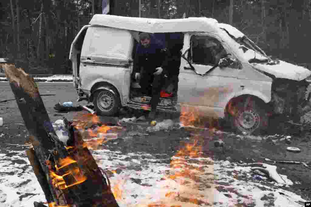 A man leaves a vehicle damaged by shelling in Brovary, outside Kyiv, March 1, 2022.