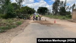 Funcionarios de Zimbabue reparan uno de los malos caminos en Harare el 1 de marzo de 2022, luego de que el gobierno liberara fondos para el programa.  (Colón Mavhunga/VOA)