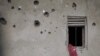 FILE - The wall of a house riddled with bullets is seen in Nzenga, which has been repeatedly attacked by the armed group Allied Democratic Forces (ADF), Beni territory, northeastern Democratic Republic of Congo, May 24, 2021.