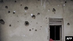 FILE - The wall of a house riddled with bullets is seen in Nzenga, which has been repeatedly attacked by the armed group Allied Democratic Forces (ADF), Beni territory, northeastern Democratic Republic of Congo, Taken 5.24.2021