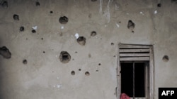 FILE - The wall of a house riddled with bullets is seen in Nzenga, which has been repeatedly attacked by the armed group Allied Democratic Forces (ADF), Beni territory, northeastern Democratic Republic of Congo, 5.24.2021