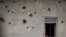 FILE - The wall of a house riddled with bullets is seen in Nzenga, which has been repeatedly attacked by the armed group Allied Democratic Forces (ADF), Beni territory, northeastern Democratic Republic of Congo, 5.24.2021
