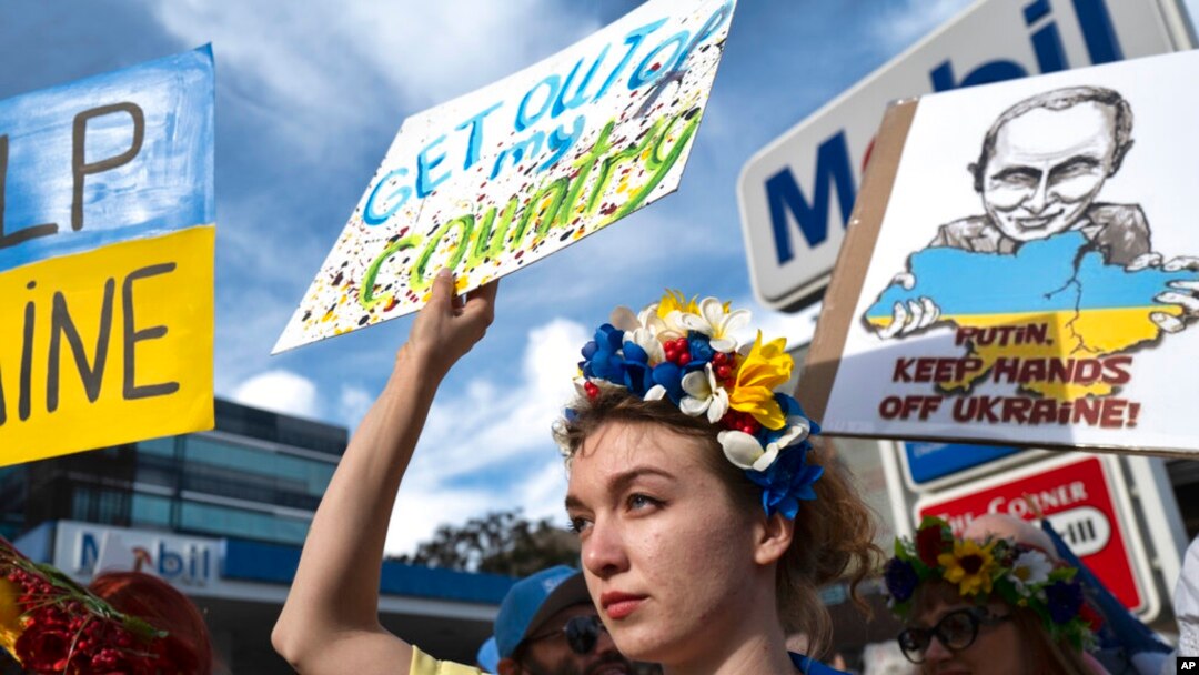 Seorang perempuan Ukraina mengacungkan poster dalam demo memprotes invasi Rusia ke Ukraina, di Los Angeles, AS, Sabtu, 26 Februari 2022. (Foto: Richard Voge/AP)