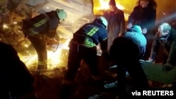 Rescuers work at the site of a Russian strike during Russia's invasion of Ukraine, in Zhytomyr, Ukraine, March 1, 2022, in this still image taken from video. (State Emergency Service of Ukraine/via Reuters)