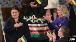 Ukraine Ambassador to the US Oksana Markarova acknowledges applause from US First Lady Jill Biden as they attend President Joe Biden's first State of the Union address to a joint session of Congress, in Washington, DC, on March 1, 2022.