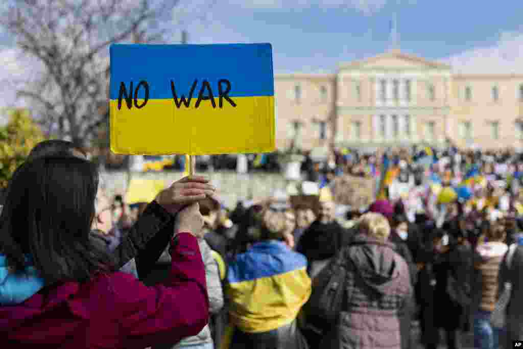 Protesters hold a placard during a rally against the Russian invasion of Ukraine, at central Syntagma square, in Athens, Greece, Feb. 27, 2022.