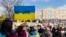 Protesters hold a placard during a rally against the Russian invasion of Ukraine, at central Syntagma square, in Athens, Feb. 27, 2022. 