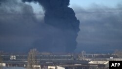 Asap hitam mengepul dari bandara militer di Chuguyev dekat Kharkiv pada 24 Februari 2022. (Foto: AFP)